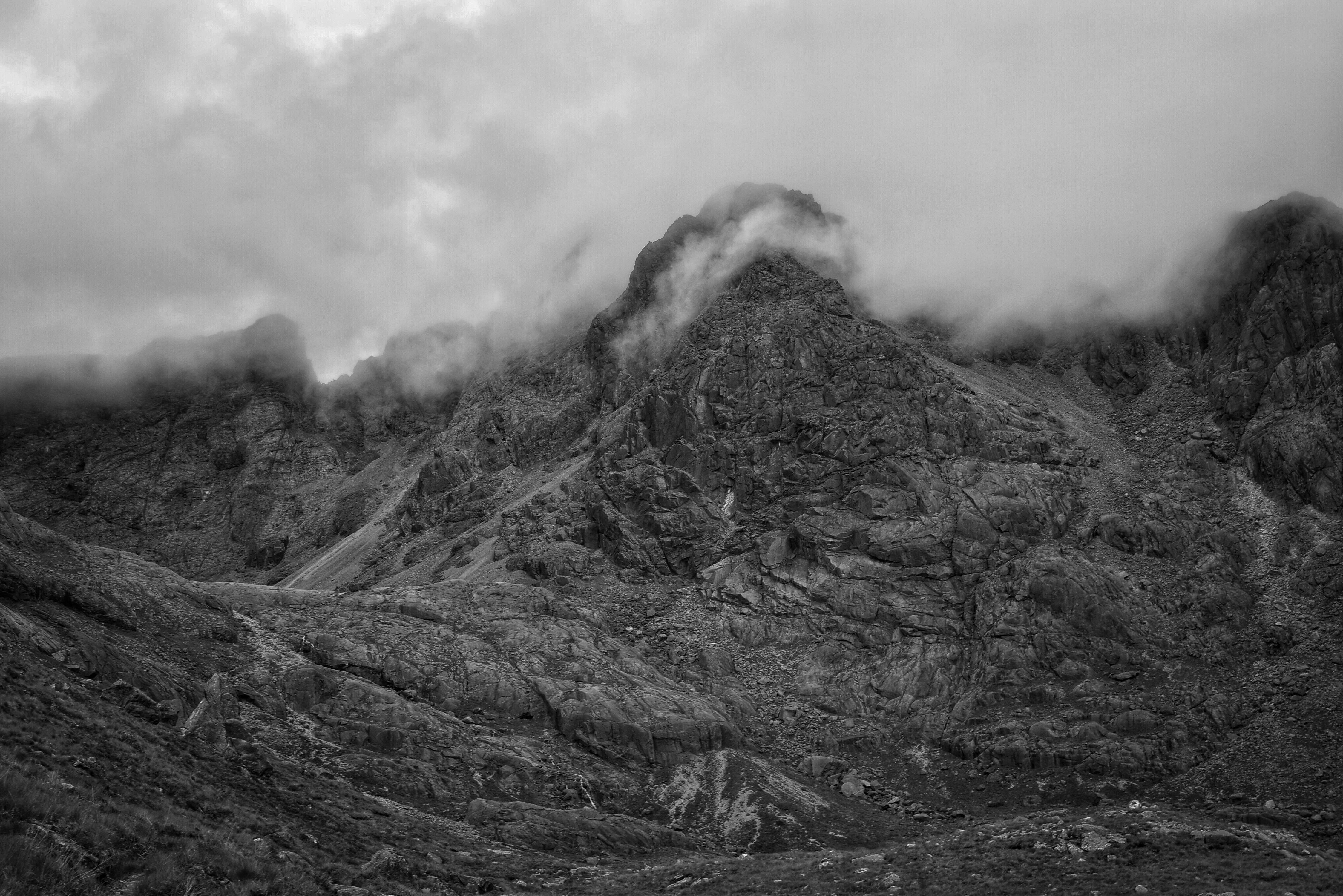 mountain range covered with clouds grayscale photography